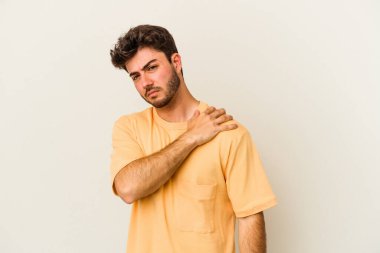 Beyaz arka planda izole edilmiş, omuz ağrısı olan genç beyaz bir adam..