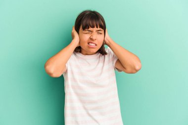 Genç melez kadın mavi kulaklarda elleri ile izole edilmiş..