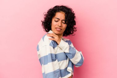 Genç kıvırcık Latin kadın pembe arka planda izole edilmiş, omuz ağrısı var..
