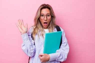 Avustralyalı genç bir öğrenci pembe arka planda izole edilmiş. Şaşırmış ve şok olmuş..