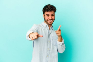 Mavi arka planda izole edilmiş genç beyaz adam öne bakan neşeli gülümsemeler.