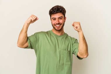 Beyaz arka planda izole edilmiş genç beyaz adam tasasız ve heyecanlı bir şekilde tezahürat yapıyor. Zafer konsepti.