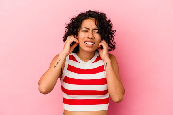 Mladá Kudrnatá Latinská Žena Izolovaná Růžovém Pozadí Zakrývající Uši Prsty — Stock fotografie