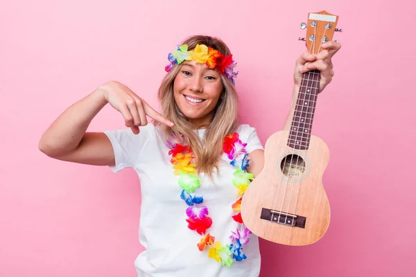 年轻的Hawaiian女人扮演一个被粉色背景隔离的Ukulele — 图库照片