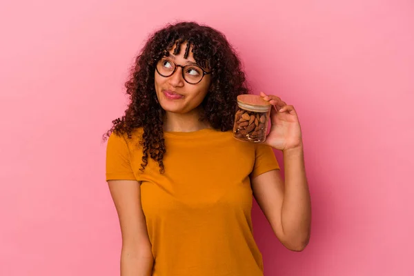 Giovane Donna Razza Mista Possesso Vaso Mandorle Isolato Sfondo Rosa — Foto Stock