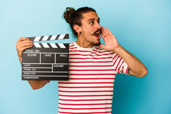 Young Caucasian Man Long Hair Holding Clapperboard Isolated Blue Background — Stock Photo, Image