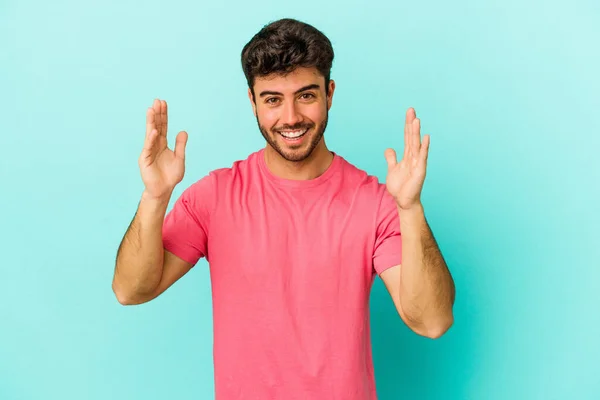 Joven Hombre Caucásico Aislado Sobre Fondo Azul Recibiendo Una Agradable —  Fotos de Stock