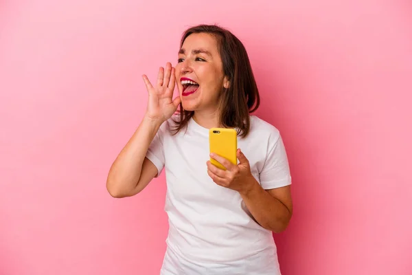 Medelålders Kaukasiska Kvinna Som Håller Mobiltelefon Isolerad Rosa Bakgrund Skrika — Stockfoto