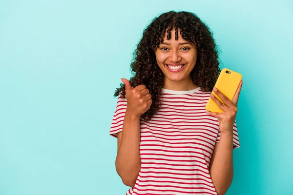 Молода Змішана Расова Жінка Тримає Мобільний Телефон Ізольовано Синьому Фоні — стокове фото