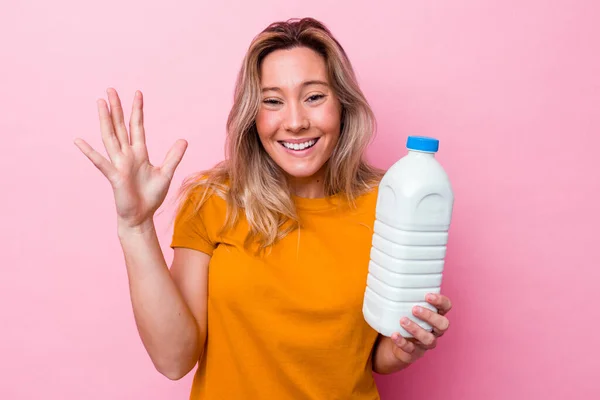 Junge Australierin Hält Eine Flasche Milch Isoliert Auf Rosa Hintergrund — Stockfoto
