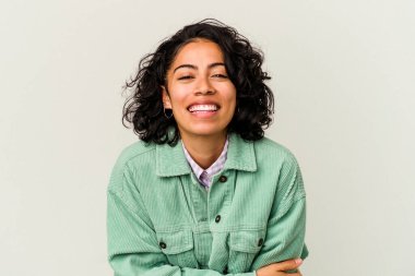 Genç kıvırcık Latin kadın beyaz arka planda izole edilmiş gülüyor ve eğleniyor..