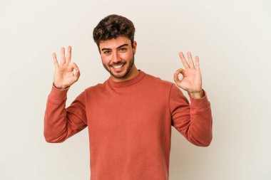 Beyaz arka planda izole edilmiş genç beyaz bir adam neşeli ve kendinden emin..
