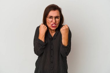 Beyaz arka planda izole edilmiş orta yaşlı beyaz kadın yumruğunu kameraya gösteriyor, agresif yüz ifadesi..