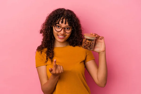 Ung Blandras Kvinna Håller Mandel Burk Isolerad Rosa Bakgrund Pekar — Stockfoto