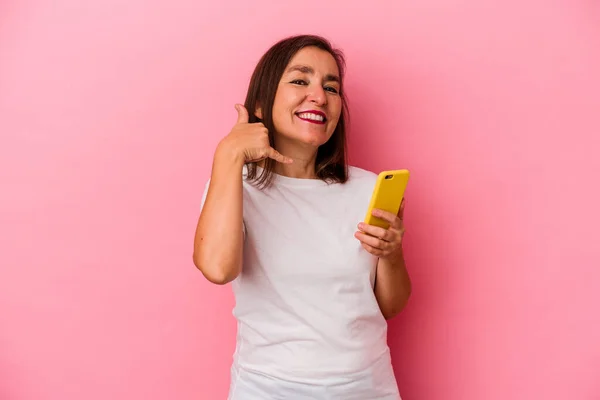 Medelålders Kaukasiska Kvinna Som Håller Mobiltelefon Isolerad Rosa Bakgrund Visar — Stockfoto