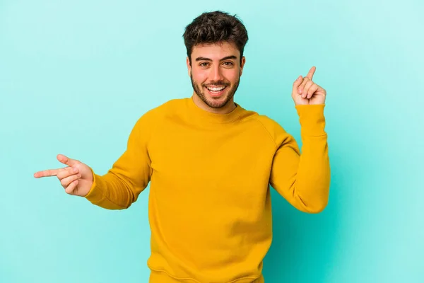 Jonge Blanke Man Geïsoleerd Blauwe Achtergrond Wijzend Naar Verschillende Kopieerruimtes — Stockfoto