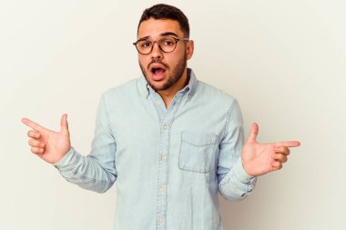 Beyaz arka planda izole edilmiş genç beyaz bir adam farklı kopya alanlarını gösteriyor, birini seçiyor, parmaklarıyla gösteriyor..