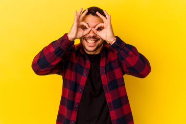 Kafkasyalı genç adam sarı arka planda izole edilmiş. Heyecanlı..