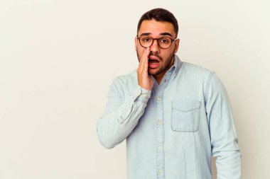 Beyaz arka planda izole edilmiş genç beyaz bir adam gizli bir sıcak fren haberi veriyor ve yana bakıyor.