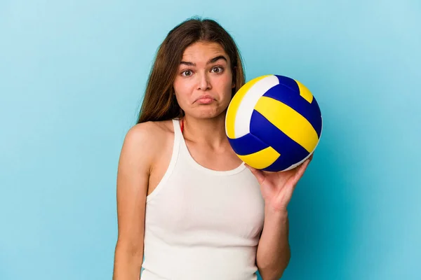 Jovem Caucasiana Jogando Vôlei Isolado Fundo Azul Encolhe Ombros Olhos — Fotografia de Stock