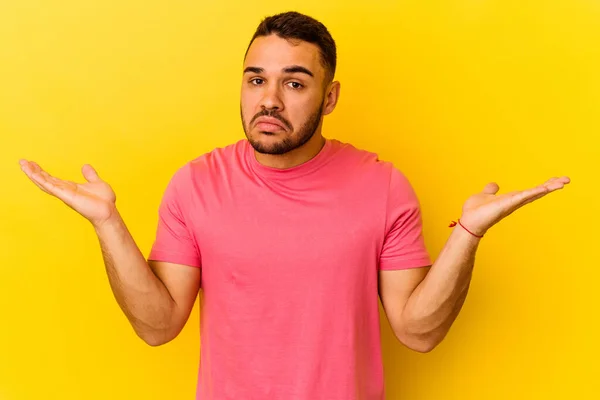 Joven Hombre Caucásico Aislado Sobre Fondo Amarillo Confundido Dudoso Hombros —  Fotos de Stock