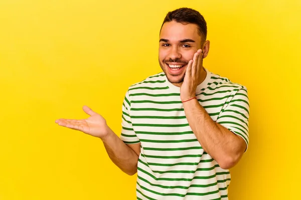 Jonge Blanke Man Geïsoleerd Gele Achtergrond Houdt Kopieerruimte Een Handpalm — Stockfoto