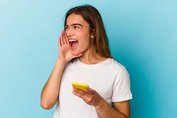 Joven Mujer Caucásica Sosteniendo Teléfono Móvil Aislado Sobre Fondo Azul — Foto de Stock