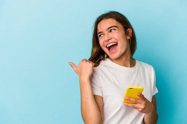 Mujer Caucásica Joven Sosteniendo Teléfono Móvil Aislado Puntos Fondo Azul — Foto de Stock