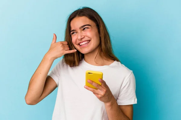 Joven Mujer Caucásica Sosteniendo Teléfono Móvil Aislado Sobre Fondo Azul —  Fotos de Stock