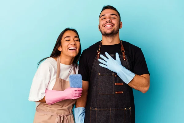 Jeune Couple Mixte Nettoyage Maison Isolé Sur Fond Bleu Rigole — Photo