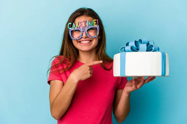 Jovem Caucasiana Segurando Bolo Isolado Fundo Azul Sorrindo Apontando Para — Fotografia de Stock