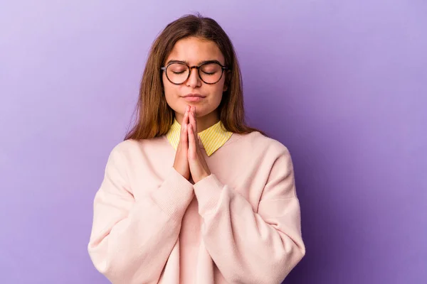 Mulher Caucasiana Jovem Isolado Fundo Roxo Mãos Dadas Rezar Perto — Fotografia de Stock