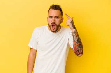 Sarı arka planda izole edilmiş genç, dövmeli beyaz adam harika bir fikri var, yaratıcılık kavramı..