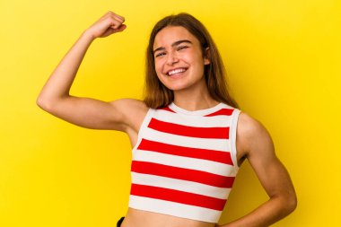 Sarı arka planda izole edilmiş genç beyaz kadın tasasız ve heyecanlı bir şekilde tezahürat yapıyor. Zafer konsepti.