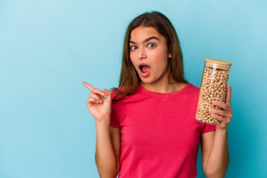 Beyaz arka planda izole edilmiş nohut kavanozu tutan genç beyaz bir adam var.