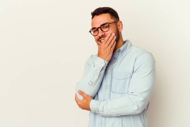 Beyaz arka planda izole olmuş genç beyaz bir adam gülüyor, kaygısız, doğal bir duygu..