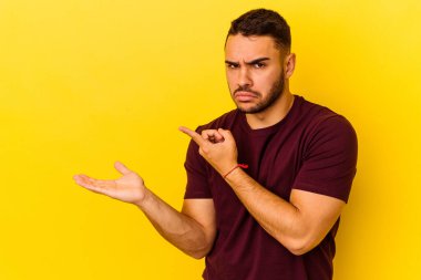 Sarı arka planda izole edilmiş genç beyaz bir adam, elinde bir fotokopi alanı tutarken heyecanlanıyor..