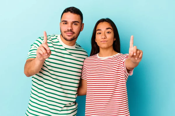 Jong Gemengd Ras Paar Geïsoleerd Blauwe Achtergrond Tonen Nummer Een — Stockfoto