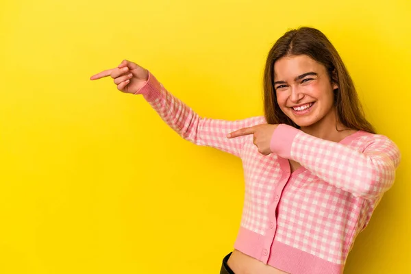 若いですCaucasian女性絶縁上の黄色の背景励起ポインティングとともに前指離れて — ストック写真