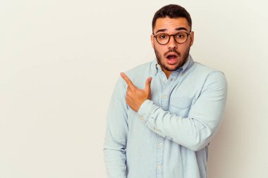 Beyaz arka planda izole edilmiş genç beyaz adam yan tarafı işaret ediyor