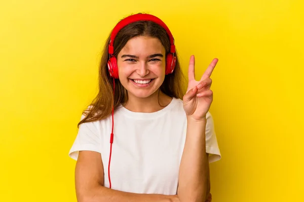 Joven Mujer Caucásica Escuchando Música Aislada Sobre Fondo Amarillo Mostrando — Foto de Stock