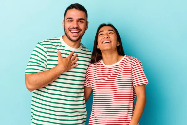 Jovem Casal Misto Isolado Fundo Azul Voz Alta Mantendo Mão — Fotografia de Stock