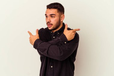 Beyaz arka plan noktalarında izole genç beyaz adam, iki seçenek arasında seçim yapmaya çalışıyor.