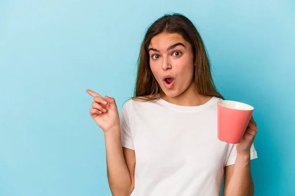 Mujer Caucásica Joven Sosteniendo Una Taza Aislada Sobre Fondo Azul — Foto de Stock