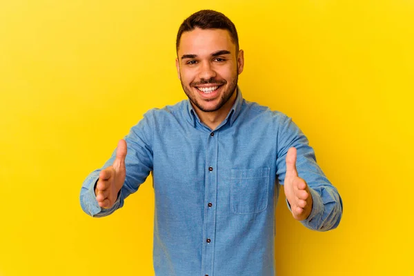 Young Caucasian Man Isolated Yellow Background Holding Something Both Hands — Stock Photo, Image