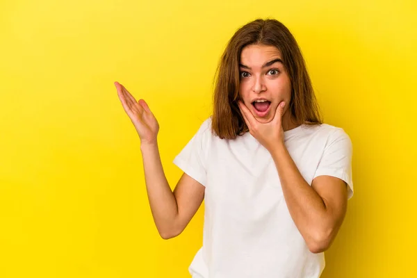 Mujer Joven Caucásica Aislada Sobre Fondo Amarillo Sostiene Espacio Copia — Foto de Stock