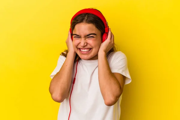 Jovem Caucasiana Ouvindo Música Isolada Fundo Amarelo Cobrindo Orelhas Com — Fotografia de Stock