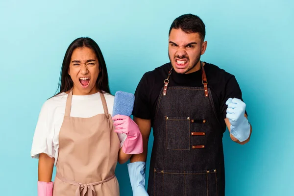Jeune Couple Mixte Nettoyage Maison Isolé Sur Fond Bleu Criant — Photo