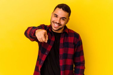 Sarı arka planda izole edilmiş genç beyaz adam öne bakan neşeli gülücükler.