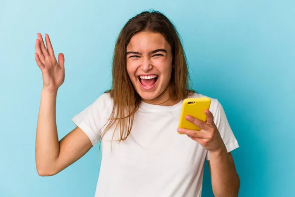 Jovem Caucasiana Segurando Telefone Celular Isolado Fundo Azul Recebendo Uma — Fotografia de Stock